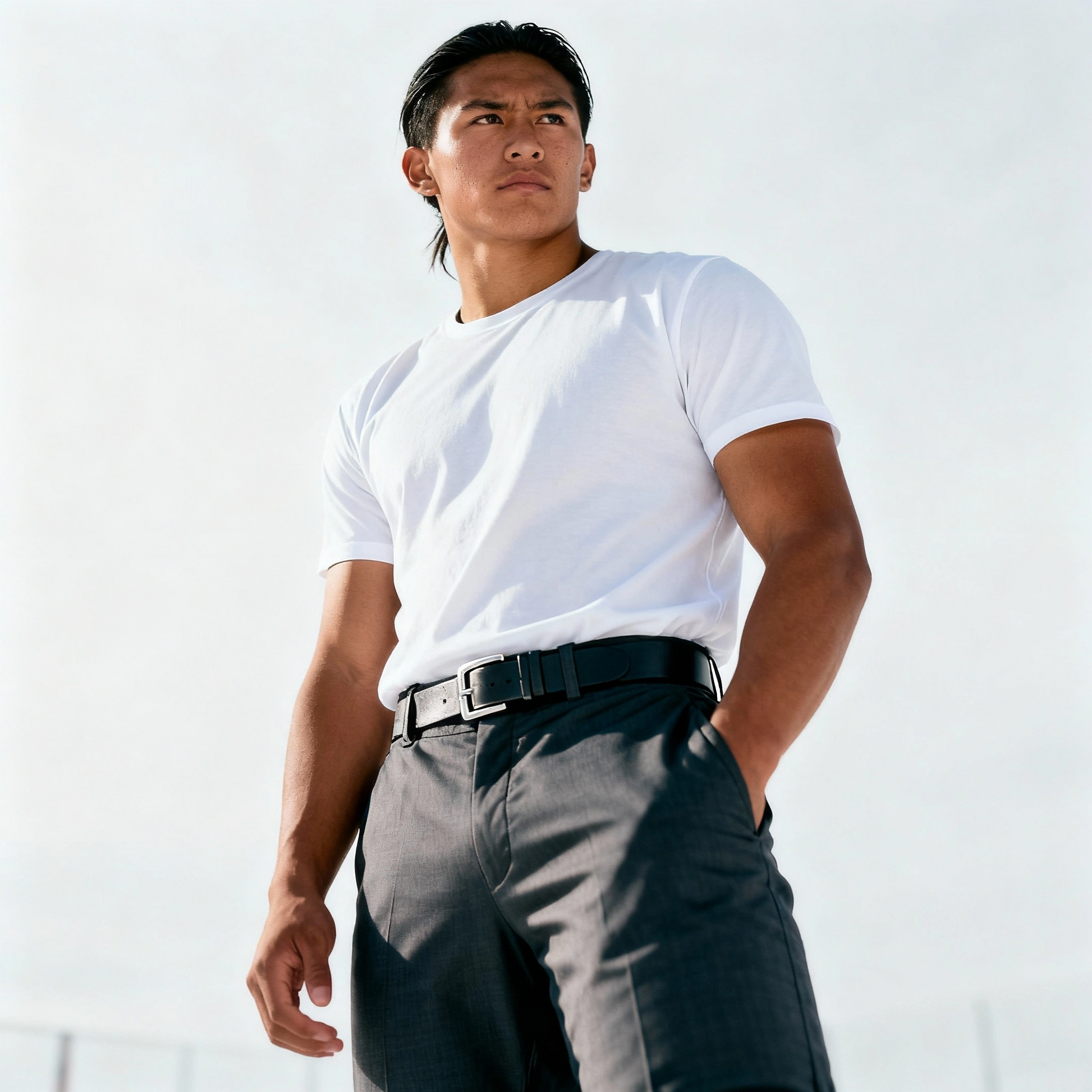 Man wearing a white t-shirt and gray pants against a light background